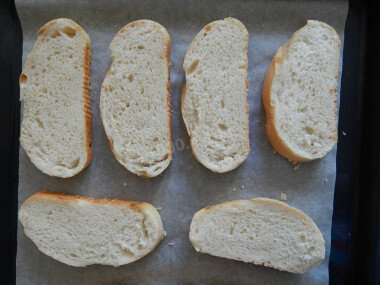 ШАГ 2:
Батон можно использовать любой: широкий, узкий, багет, чем уже будет батон, тем меньше получатся по размеру пиццы. Приготовленные кусочки батона выкладываем на застеленный пергаментом противень.