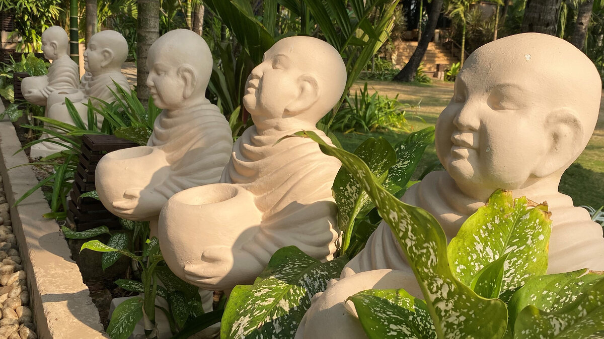 Статуи буддийских монахов в парке цветов, Северный Гоа, Индия.