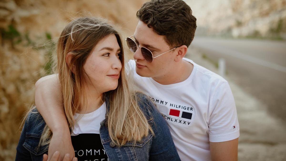    Мужчина и женщина смотрят друг на друга влюбленными взглядами на фоне дороги:Pexels