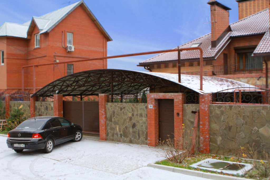 Машина на парковке у ворот кирпичного дома. Фото с сайта domsbobrom.com