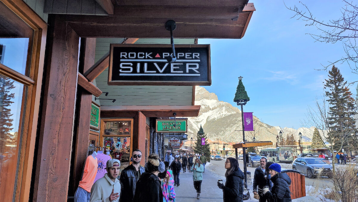 Фото 1. Вывеска магазина. Банф, Канада, январь  2023. Посмотрите на фото - многие люди без шапок, без шарфов, без курток. На улице минусовая температура. Поражаюсь канадцам.