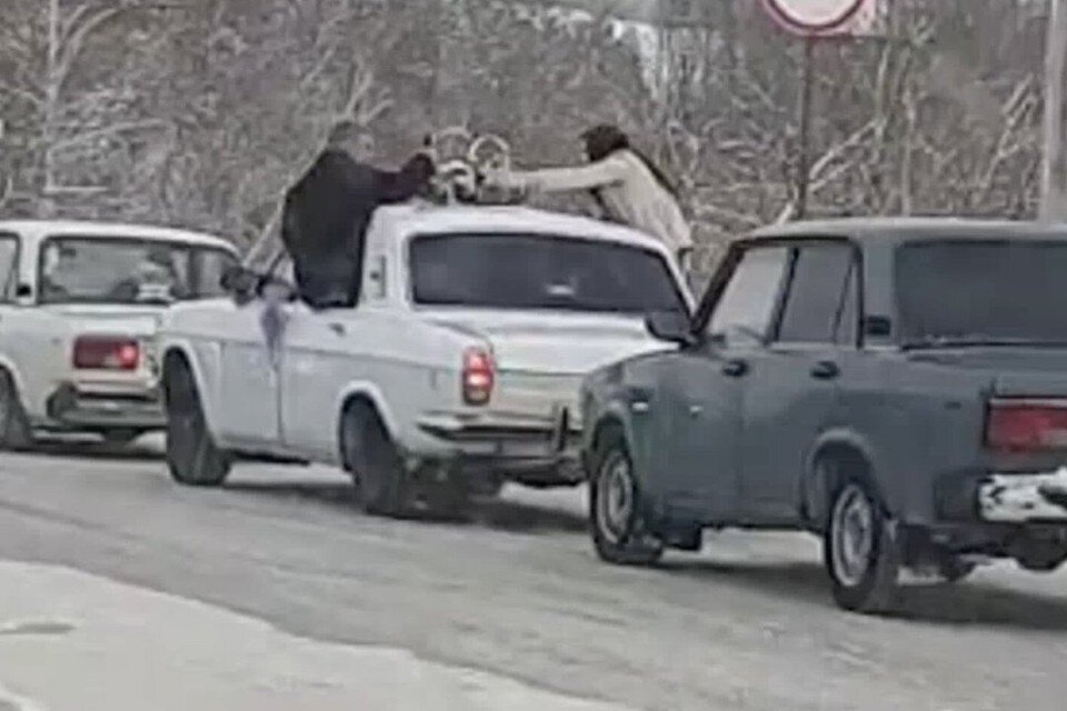    Молодожены вылезли из окна авто и схватились за кольца на крыше. Фото: предоставил читатель КП-Новосибирск Фокс