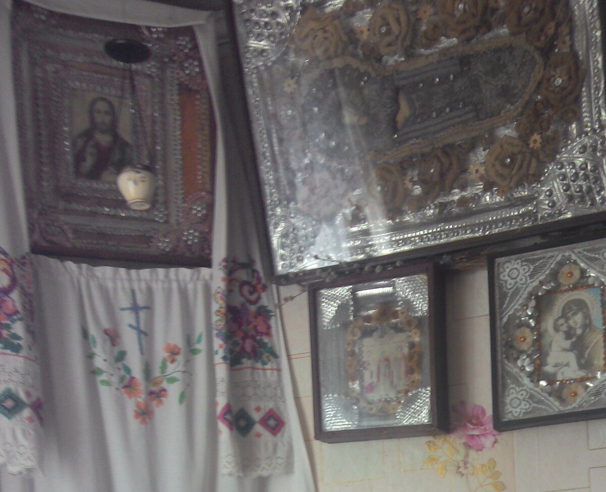 Большая икона справа. Лицо и руки Божьей матери нарисованы на дереве, а вокруг бисерный оклад. Когда мы попытались помыть бисер, он стал сыпаться. Видимо нити, соединяющие его, сгнили от времени.