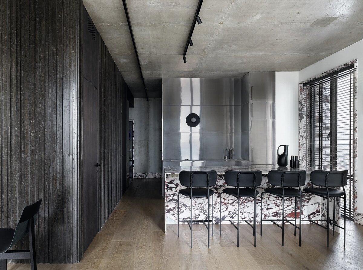 Фото: Сергей Ананьев; стилист: Наталья ОнуфрейчукВид из зоны гостиной в сторону прихожей. Слева в темном кубе, отделанном мрамором от Salvatori, находятся ванная комната и постирочная. Кухня из нержавеющей стали сделана на заказ.