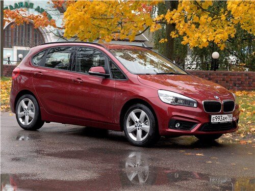Впервые, BMW 2 Series Active Tourer предстал перед широкой публикой на международном весеннем женевском автосалоне еще в 2013 году. Модель полна революционных решений, не свойственных немецкому производителю. Она получила платформу UKL1 от MINI Cooper,широкий список опций и актуальный, на данный момент, фирменный дизайн. В глаза бросаются стильные, заходящие на крылья, фары головного освещения с несколькими фокусирующими линзами и изящными секциями светодиодных дневных ходовых огней. Решетка радиатора представлена в виде двух крупных ноздрей. Они забраны множеством тонких горизонтально ориентированных ребер и щеголяют хромированной окантовкой. Внизу, на переднем бампере, расположился небольшой трапецеидальный воздухозаборник, прикрытый пластиковой решеткой. По бокам от него можно увидеть специальные углубления с черными вставками. Они придают передку довольно агрессивный внешний вид и служат пристанищем для противотуманных фар. В общем и целом, дизайнерам отлично удалось скрестить довольно громоздкий кузов с динамичными чертами, более традиционных баварских моделей.

РАЗМЕРЫ
БМВ 2 Актив Турер- это пятиместный компактвэн премиум класса. Его габаритные размеры составляют: длина 4342 мм, ширина 1800 мм, высота 1555 мм, а колесная база- 2670 мм. Клиренс среднестатистический- 156 миллиметров. Такой дорожный просвет свойственен автомобилям, чья стезя- асфальтированные улицы и загородные магистрали. Они отлично держат дорогу, могут заехать на небольшой бордюр и не теряют устойчивость, даже на относительно высоких скоростях.

Благодаря вместительному двухобъемному кузову, автомобиль обладает просторным багажником. При поднятых спинках второго ряда сидений, сзади остается около 468 литров свободного пространства. Благодаря такому объему, компактвэн отлично подойдет для повседневных задач городского жителя, а также сможет принять на борт несколько крупных чемоданов, во время длительной загородной поездки. Если, по прихоти судьбы, владельцу придется взять на борт длинномерный груз- он всегда сможет пожертвовать посадочными местами в салоне и сложить спинки заднего ряда. В таком положении, освобождается вплоть до 1510 литров полезного пространства.

ТЕХНИЧЕСКИЕ ХАРАКТЕРИСТИКИ
Актив Турер получил довольно необычную, для немецкого производителя, компоновку. У него поперечное расположение двигателя, механические и автоматические коробки передач, а также базовый передний привод. Компактвэн получил полностью независимую подвеску- McPherson спереди и многорычажку сзади, дисковые тормоза и электрический усилитель руля.

На отечественном рынке, BMW 2 Series Active Tourer предлагается с одним единственным двигателем- это рядный трехцилиндровый бензиновый турбированный агрегат на 1499 кубических сантиметров. Несмотря на скромный объем, фирменный механизм изменения фаз газораспределения и турбокомпрессор системы Twin-Scroll позволили инженерам выжать 136 лошадиных сил в диапазоне от 4500 до 6000 об/мин и 220 Нм крутящего момента начиная уже с 1250 оборотов коленчатого вала в минуту. Благодаря раннему подхвату и неплохой “полке”, автомобиль довольно динамичен. В зависимости от типа коробки передач, он ускоряется до сотни за 9,3-9,6 секунды и способен разогнаться вплоть до 200 километров в час. Благодаря скромному объему и высокому КПД, мотор довольно экономичен. Компактвэн, оборудованный механической коробкой передач, потребляет 6,1 литра бензина на сто километров пути в городском темпе движения с частыми ускорениями и торможением, 4,2 литра во время размеренной поездки по загородной трассе и 4,9 литра топлива на сотню в комбинированном цикле движения.