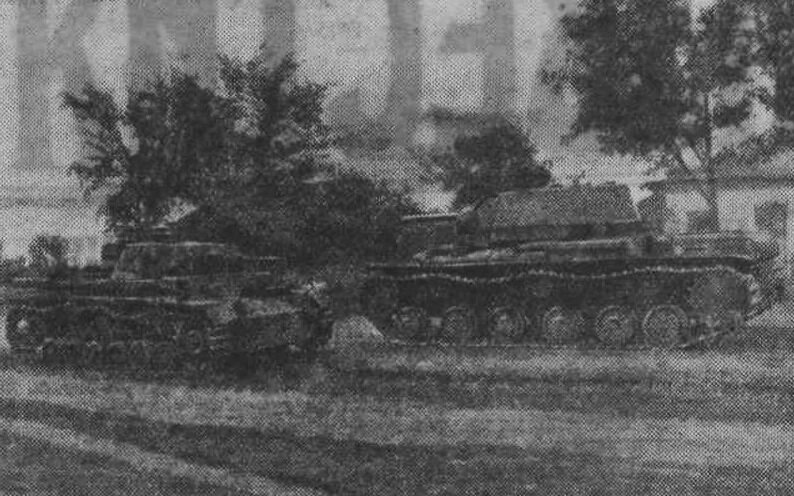 Советский танк (справа) проходит мимо подбитого им на подступах к Киеву фашистского танка. ("Известия", № 218 от 16.09.1941)