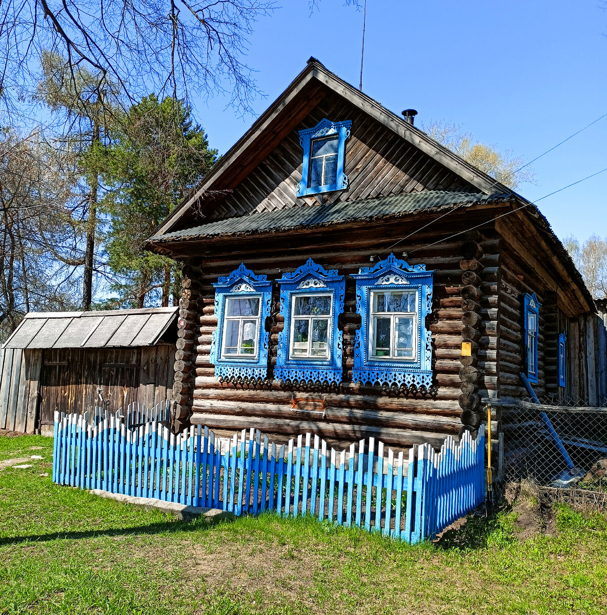 Полностью сохранившаяся русская изба с резными окнами и палисадником