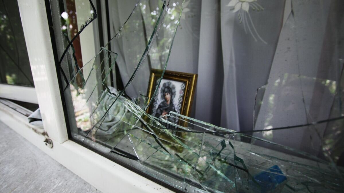    Разбитое окно дома в поселке Октябрь Донецкой области© РИА Новости / Сергей Аверин