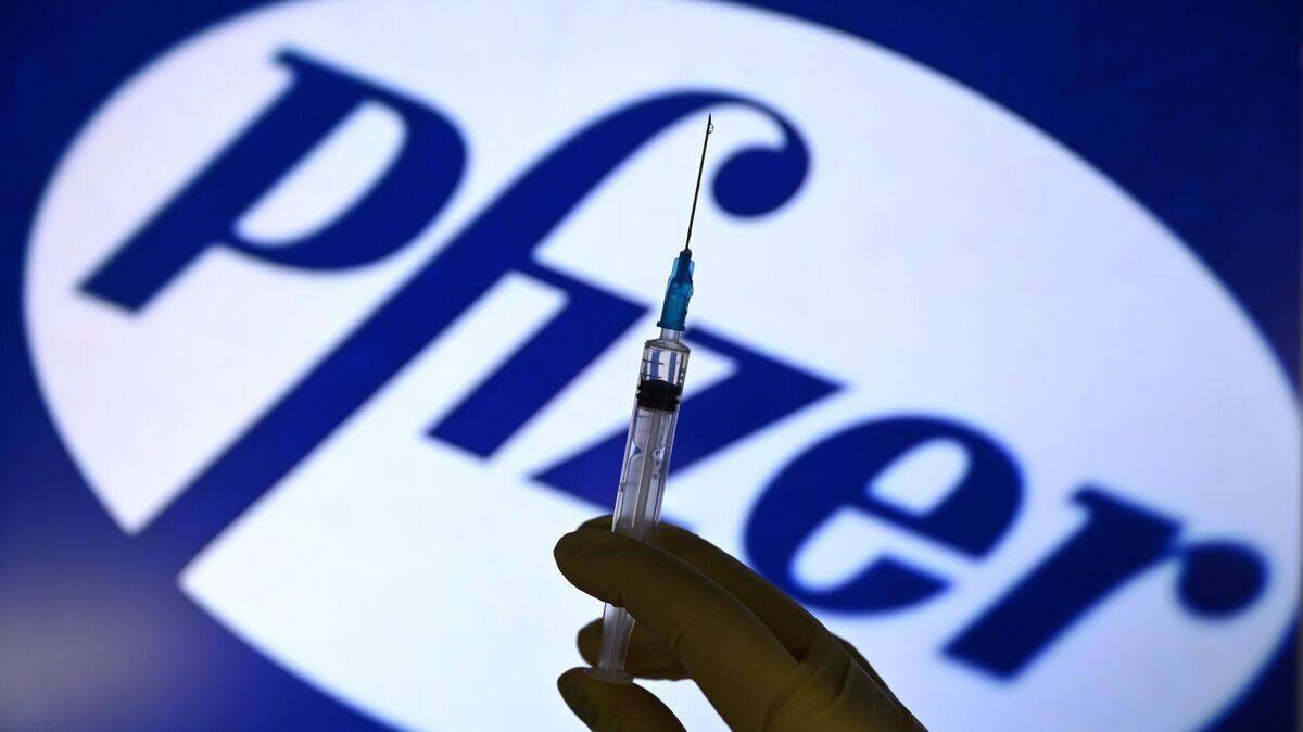    Шприц на фоне логотипа Pfizer© РИА Новости / Владимир Трефилов