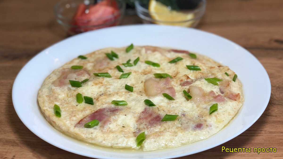 Приготовила омлет с беконом на сковороде.