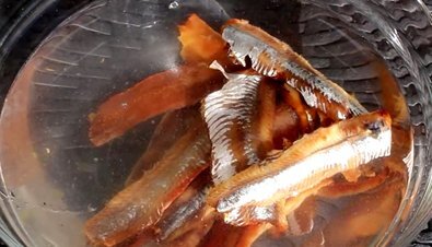 Начните приготовление этой необычной, но очень вкусной закуски. Выберите хорошие куски (желательно, чтобы это было филе) копченой сардины. Поместите рыбу в глубокую миску и залейте, чтобы полностью покрыло, холодной водой. Оставьте филе вымачиваться приблизительно на 30 минут.