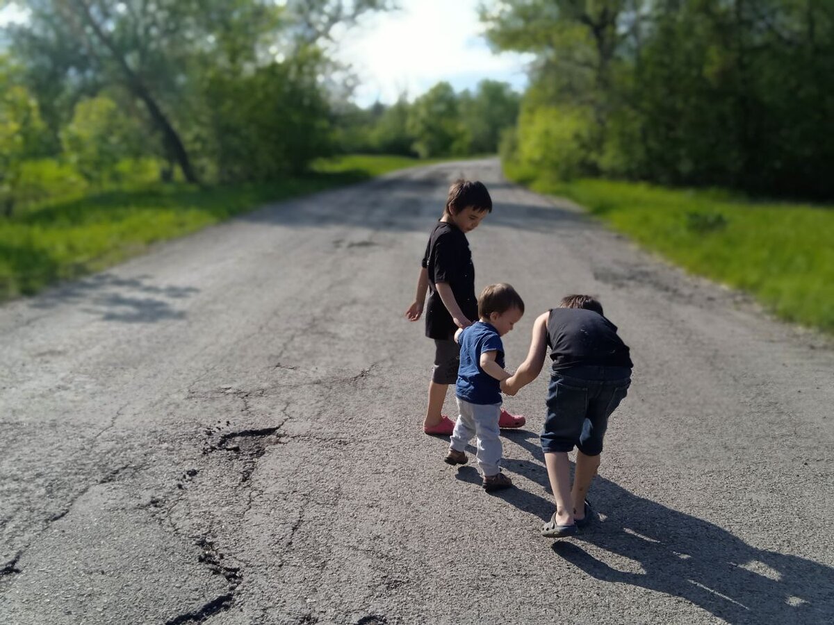Мальчик встретил маму по дороге. Ребенок тащит стул.