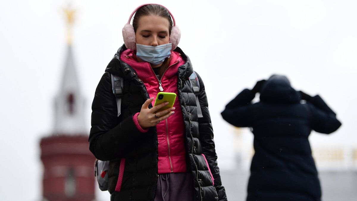    Девушка в маске со смартфоном© РИА Новости . Алексей Майшев