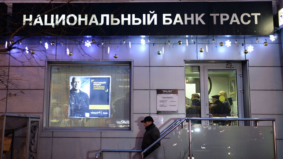    Клиент выходит из офиса банка "Траст" в Москве© РИА Новости