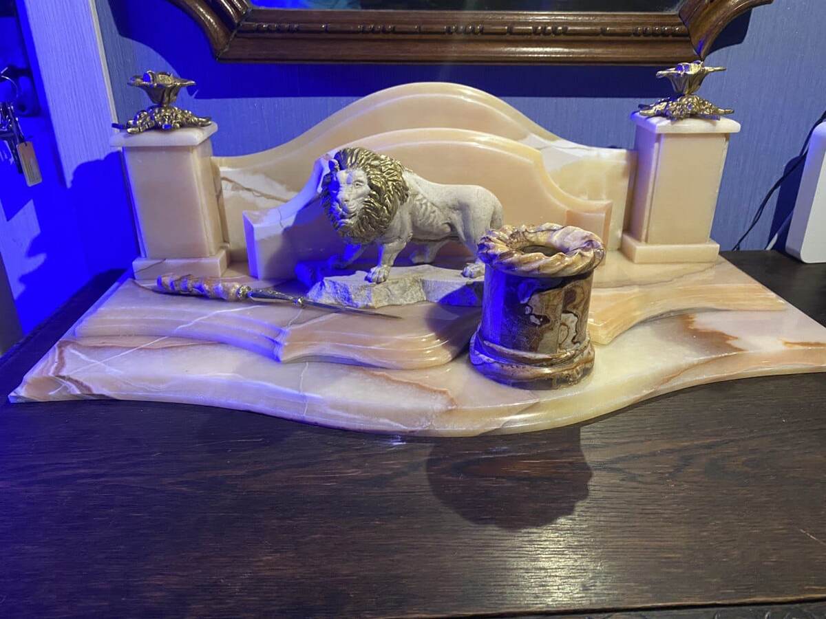 Кабинетный набор из оникса Оникс ALABASTRO EGIZIANO и Tiger Onyx (Стаканчик для
 карандашей, ручка ножа, панно на фасаде) с авторской скульптурой Льва золотой
 гривой из мрамора Crema Marfa (Испания). Набор украшен стеаринной бронзой с
 покрытием золота 24 карат. Грива льва покрыто тоже этим золотом.