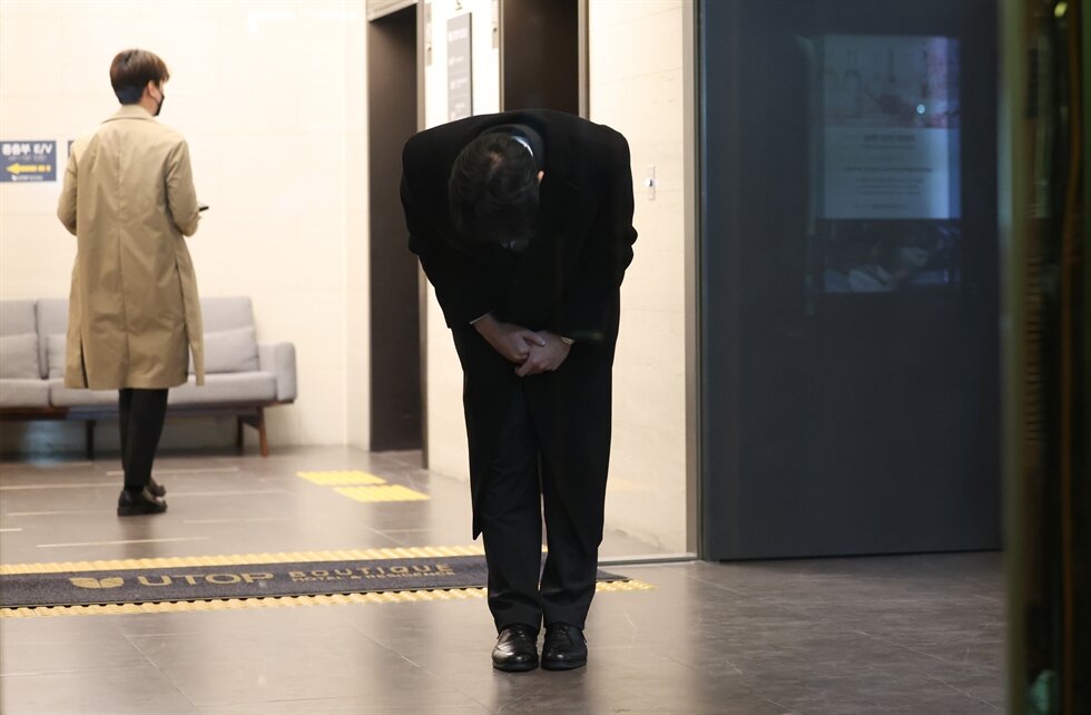 Чон У Вон кланяется журналистам перед отелем по прибытии в Кванджу.