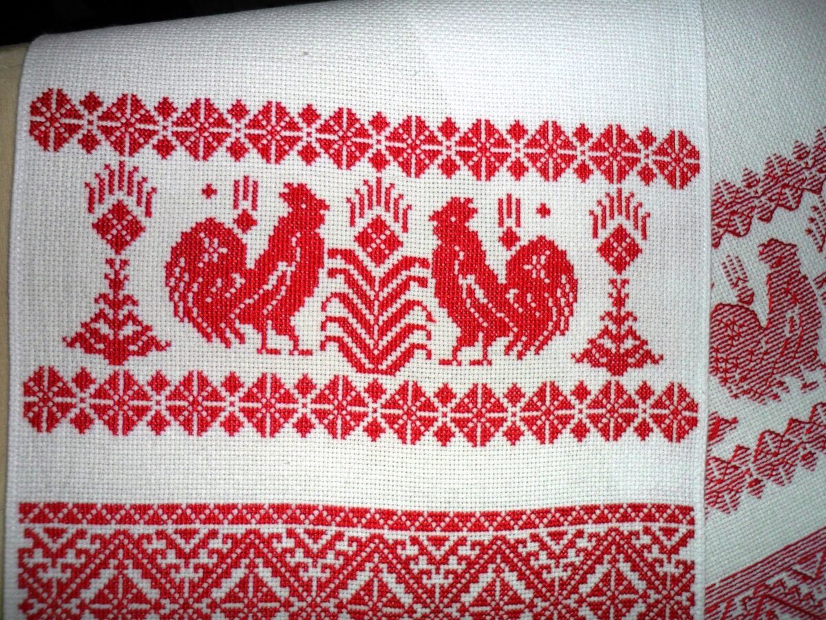 Рушник с традиционной вышивкой красной нитью по белой ткани.