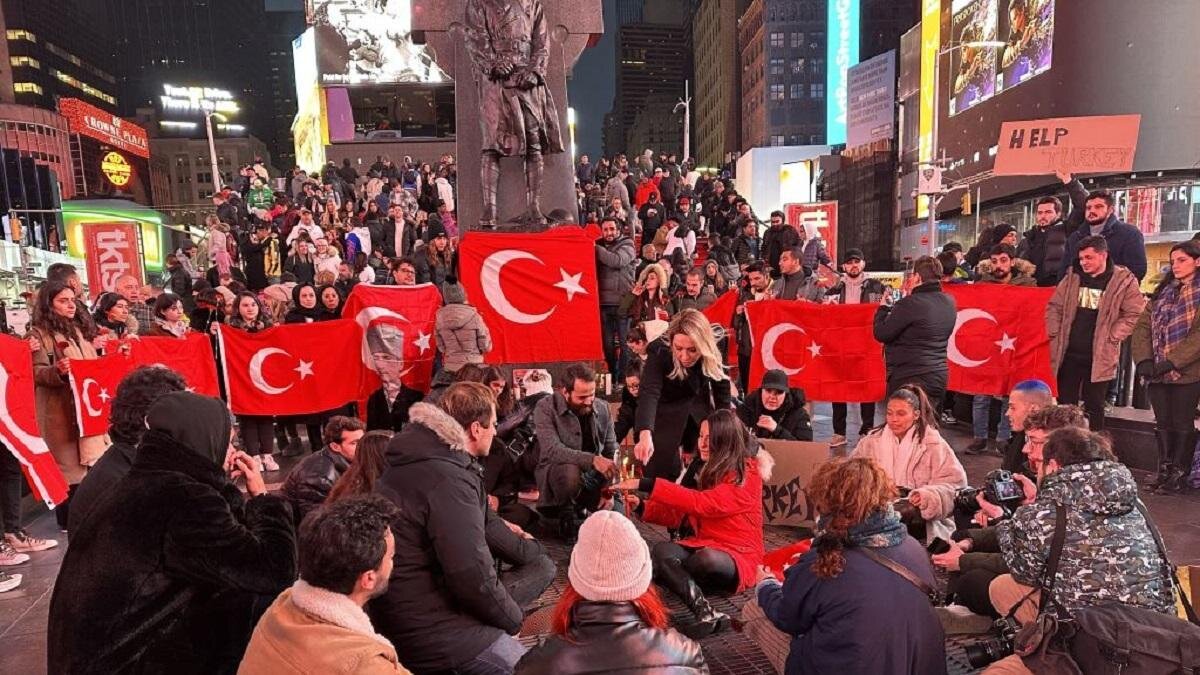    Люди с турецкими флагами стоят на улице:Tugcenur Akgun / Anadolu Agency / Getty Images