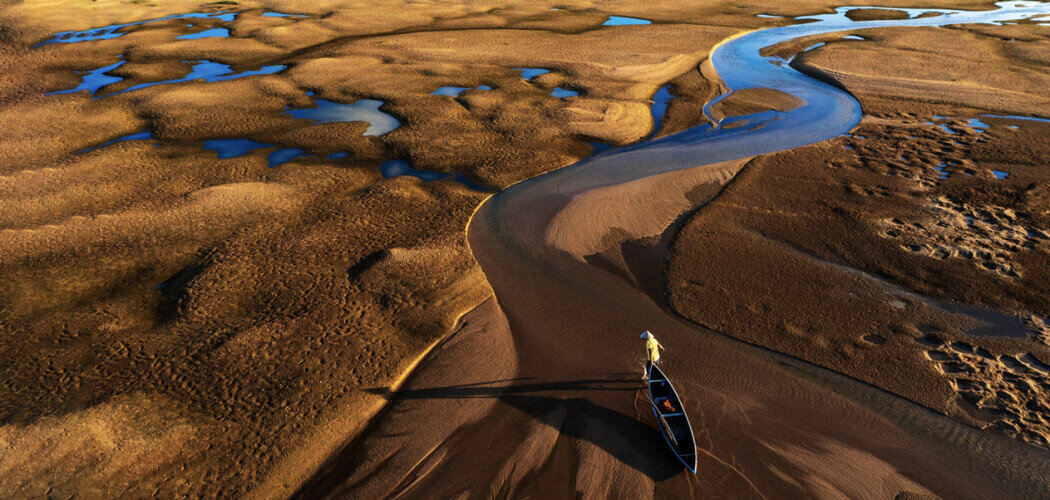 «Путь назад», Река Ки Ло, провинция Фуйен, Вьетнам. Там местные жители ловят рыбу и собирают улиток, в дни отливов людям приходится пробираться домой по мелководью пешком Фото: © Trung Lê Chí / Drone Photo Awards / Siena Awards