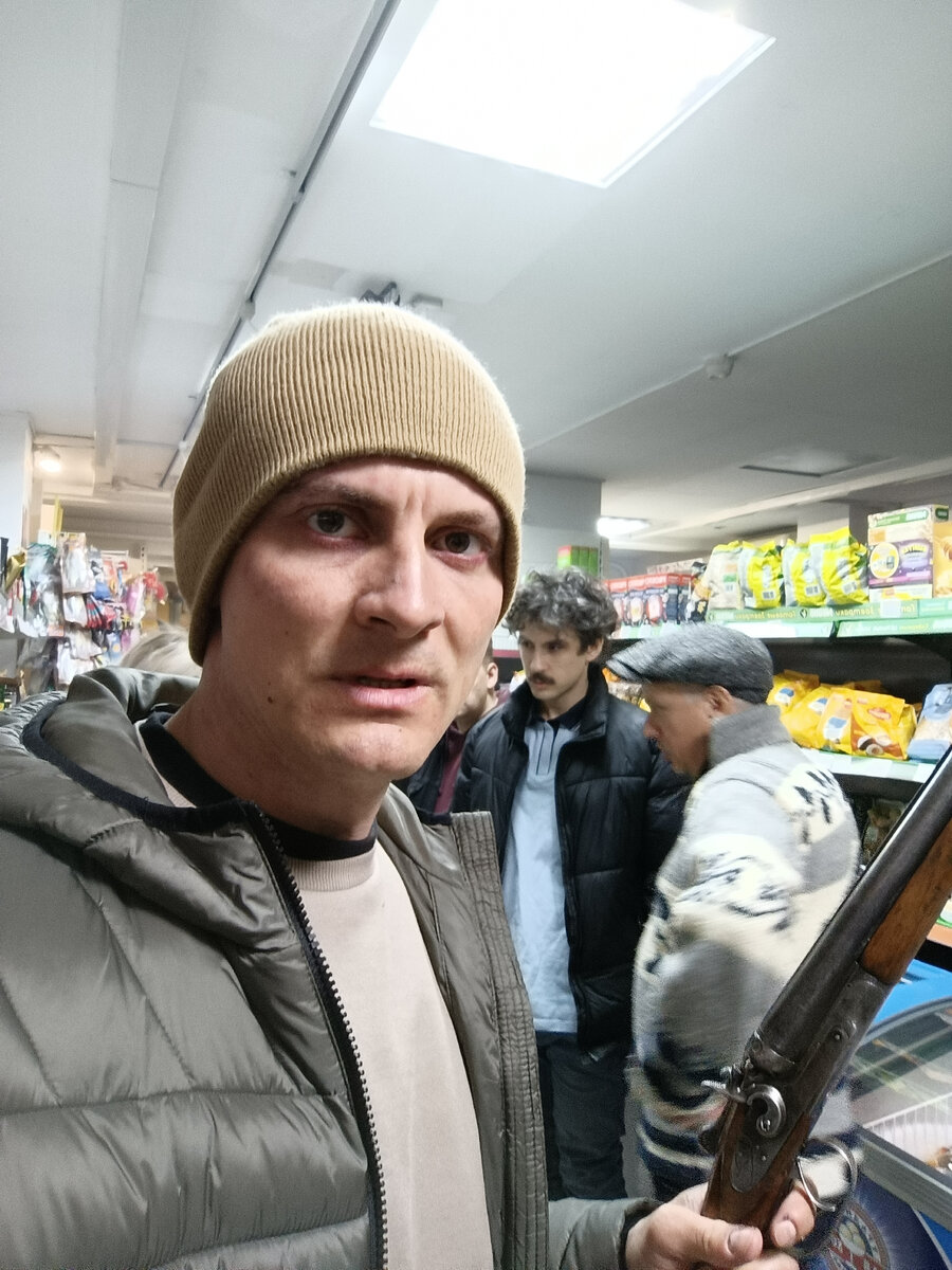 Готовлюсь прессовать заложников. На заднем плане режиссёр Виктор Шкуратов обсуждает нюансы сцены с другими актёрами.