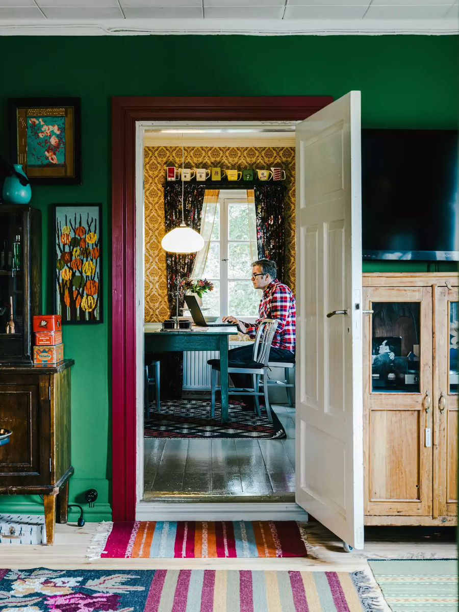 Глава семьи работает за ноутбуком в столовой. Площадь дома — 80 квадратов, на которых располагаются три комнаты и кухня