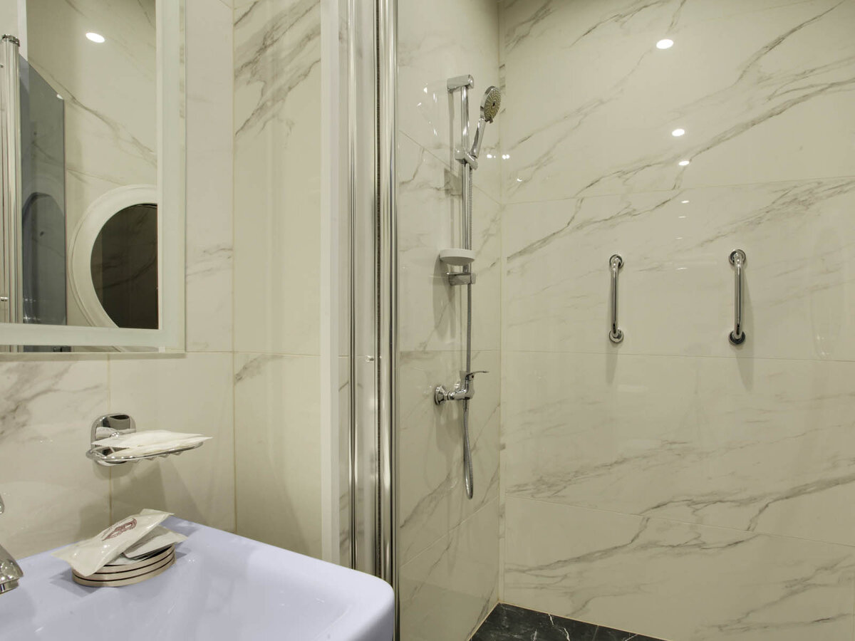 Поручни в душе в номере "Рай и ад" в отеле Подушкин на Васильевском острове в Санкт-Петербурге. 