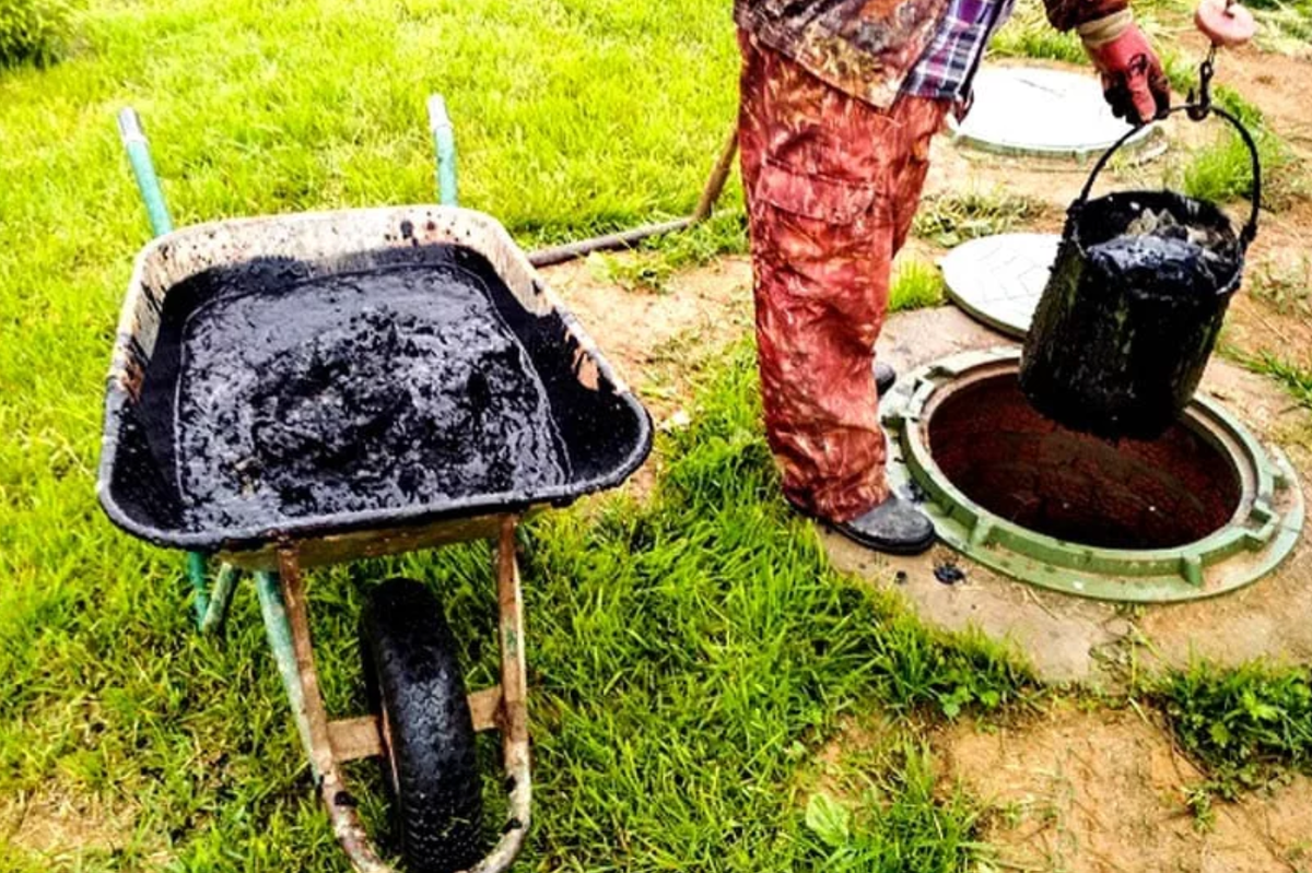 Очистка выгребной ямы из колец при помощи ведра и тачки