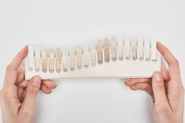 Зубные протезы не делают по умолчанию белоснежными, а подбирают по цвету к зубам пациента. Например, индекс А на шкале обозначает красновато-коричневые оттенки, индекс В — желтоватые.