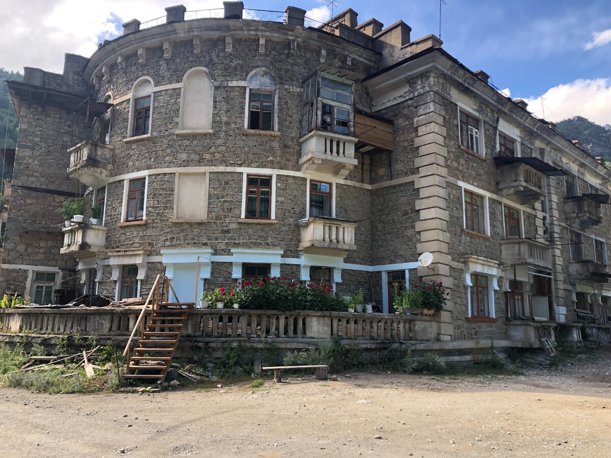 Знаменитый полукруглый дом и розы на балконе, как символ жизни в когда-то цветущем посёлке...