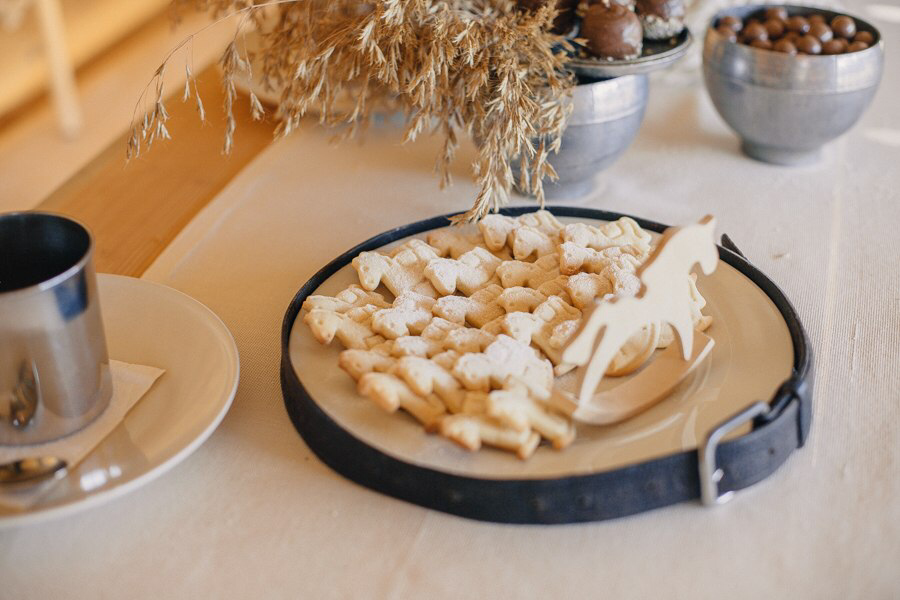 Лошадки из песочного теста на тарелке, вокруг которой обернут кожаный ремень.