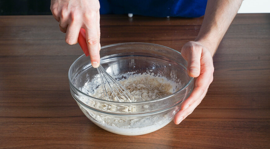 1. Приготовьте опару для тонких дрожжевых блинов. В большую миску влейте 1 стакан теплого молока и разведите в нем дрожжи. Добавьте половину просеянной муки. Тщательно выместите. Накройте миску с опарой полотенцем и оставьте в теплом месте на 30–40 минут.