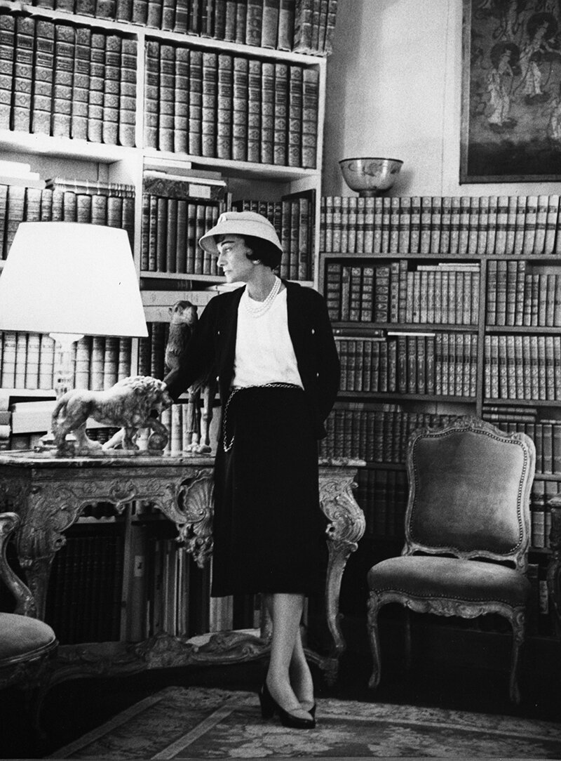 Коко Шанель на фоне своей библиотеки в парижской квартире на рю Камбон 