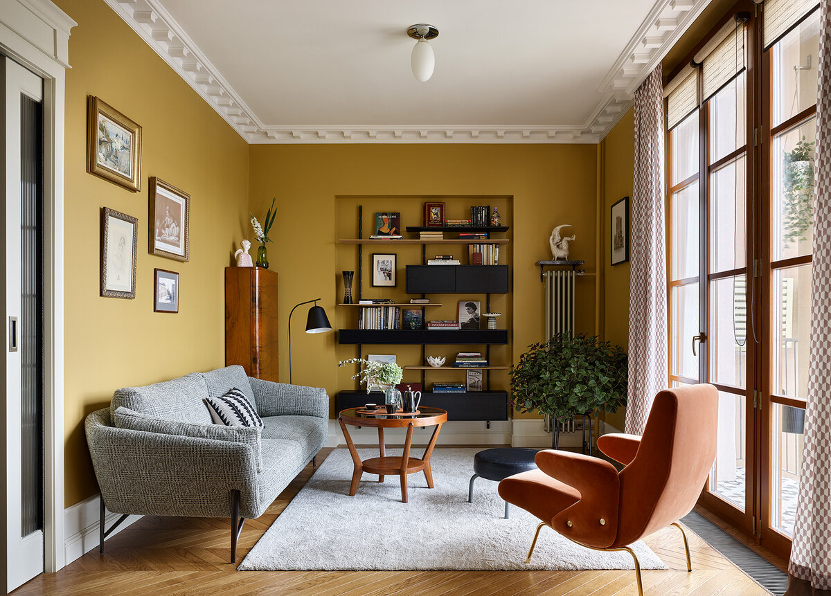 На стенах гостиной краска марки Sherwing Williams; диван Venere, Calia; кресло Delfino по дизайну Эрберто Карбони, Arflex; слева в углу часть винтажного серванта и столик производства ГДР; торшер марки 101Cph; стеллаж Reolsystem, Liva.