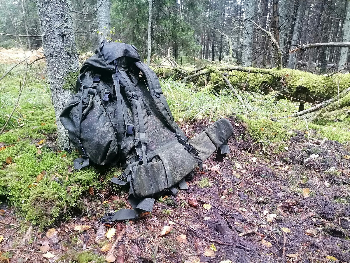 Наполовину заполненный рюкзак в лесу