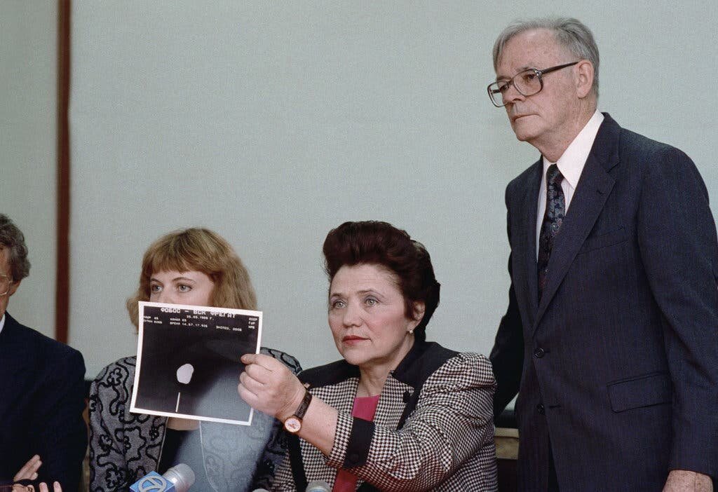 Марина Попович, "Мадам МИГ", советский летчик-испытатель, держит фотографию того, что, по ее утверждению, было НЛО вблизи Фобоса, одной из двух лун, вращающихся вокруг Марса, на пресс-конференции в советском консульстве в Сан-Франциско в 1991 году. Фото: Associated Press 