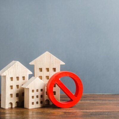    Apartment buildings and red prohibition symbol NO. Unavailable and expensive housing. Lack of living space and the impossibility of building a new one. Floor restrictions and prohibitions. Валерий