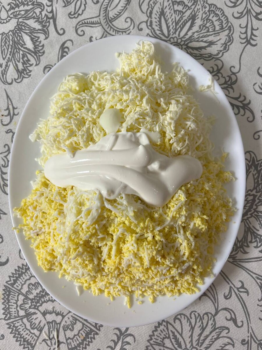 На мелкой терке трем яйца и плавленый сыр ( сыр убрать в морозильную камеру минут на 30). Добавляем майонез. Далее сворачиваем в рулетик, как показано ниже.