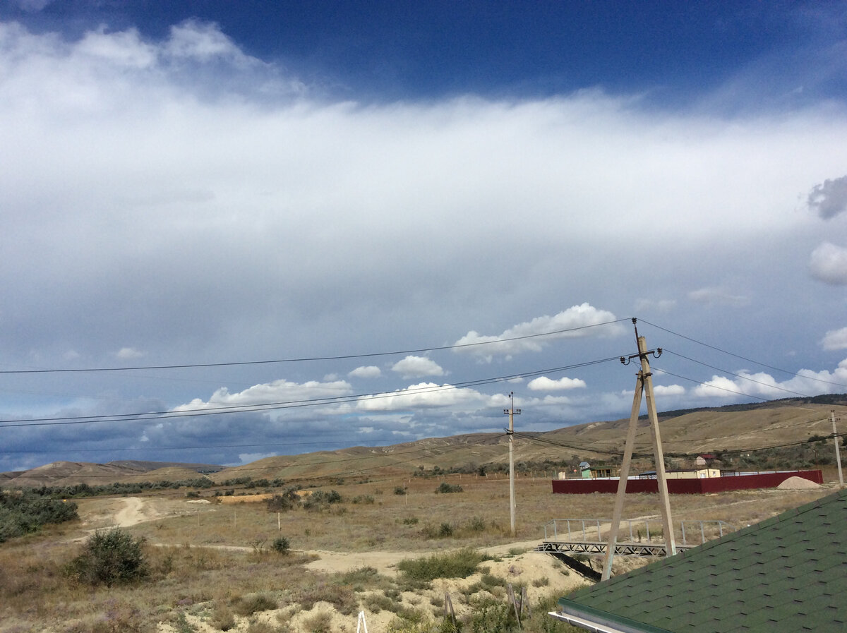На переднем плане над степью быстро бегущие «сливочные» облака, выше над перевалом почти неподвижная «слойка»