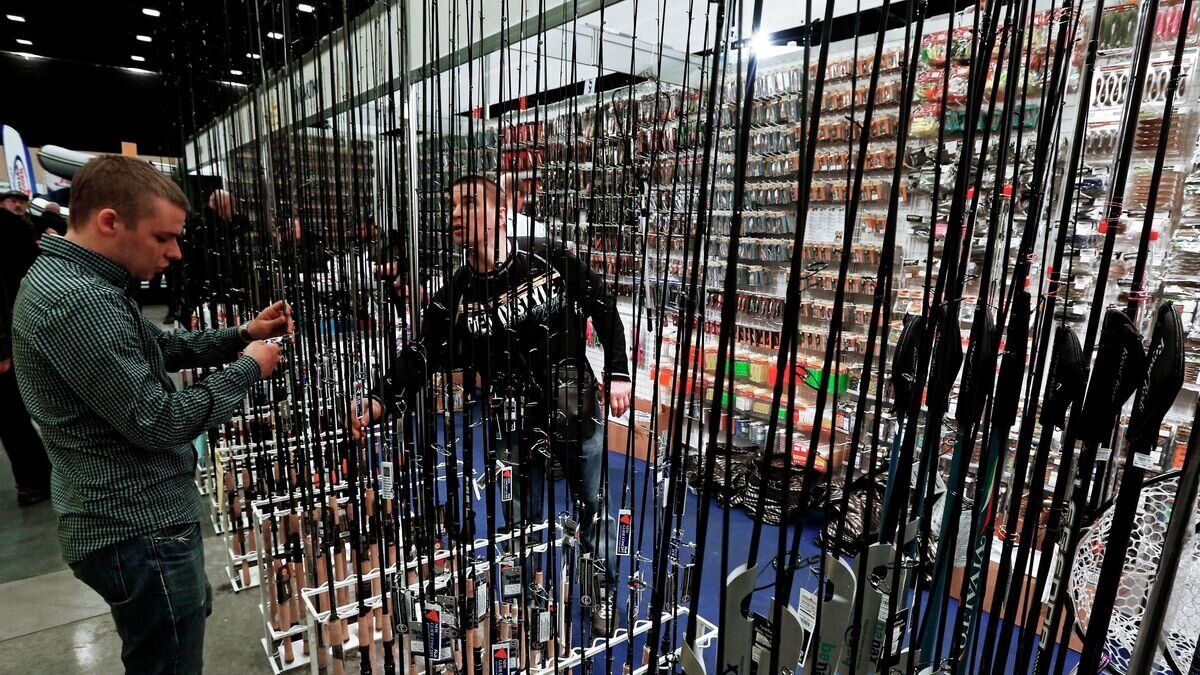    Посетитель у стенда с рыболовными снастями на международной выставке "Охота и рыболовство"© РИА Новости / Александр Демьянчук