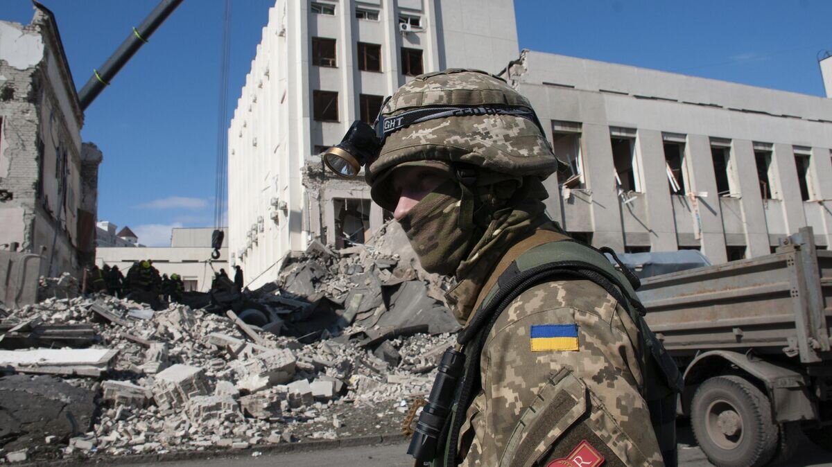    Украинский военнослужащий около здания Национальной академии государственного управления в Харькове© AP Photo / Andrew Marienko