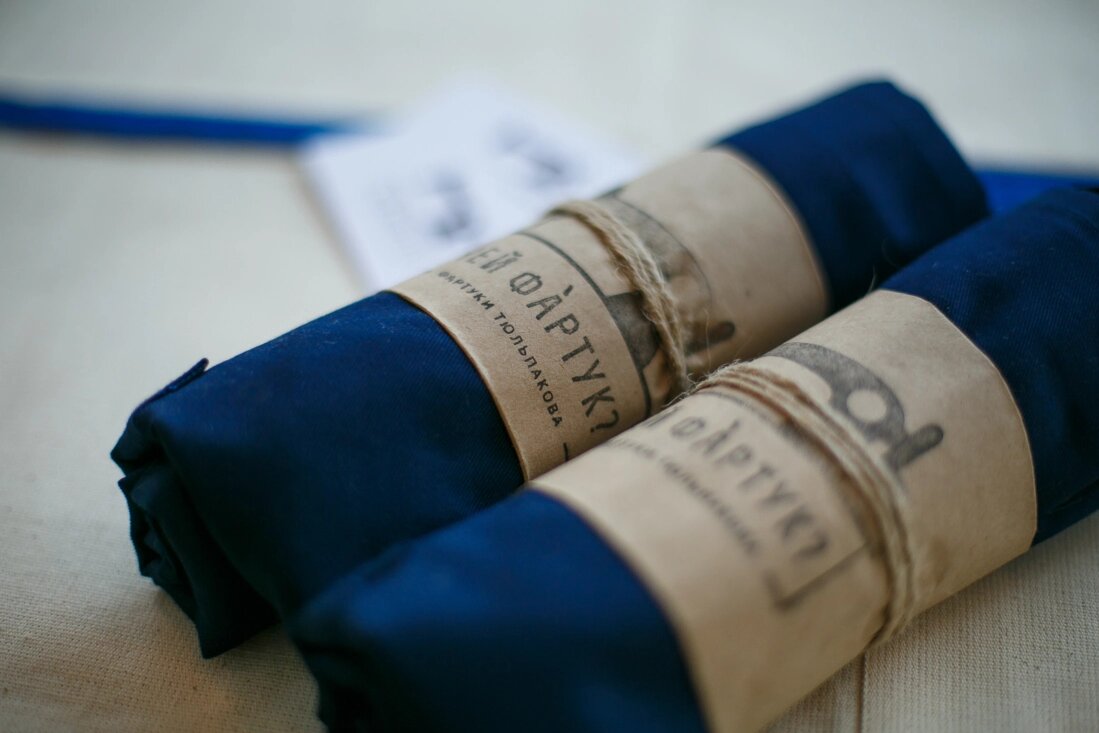 Упаковка фартуков тоже ручной работы: крафтовая бумага, грубая нить и штемпельный оттиск.