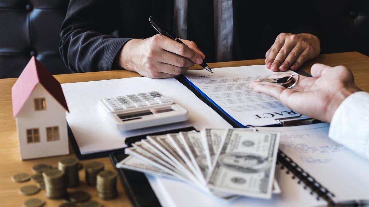    Покупатель подписывает договор о покупке жилья:Ngampol Thongsai/EyeEm/Getty Images