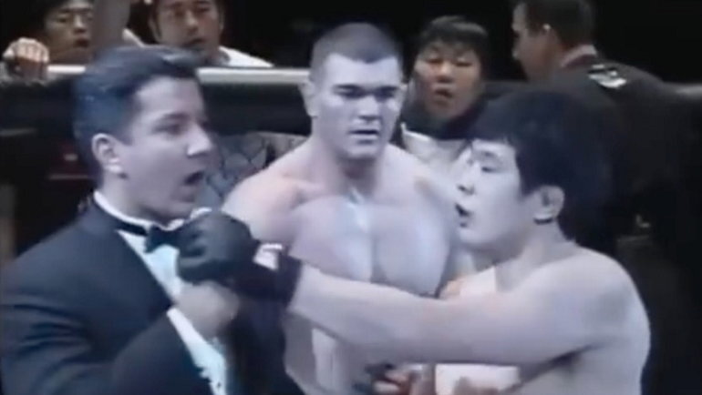    Кадзуши Сакураба пытается отнять микрофон у Брюса Баффера.Скриншот трансляции