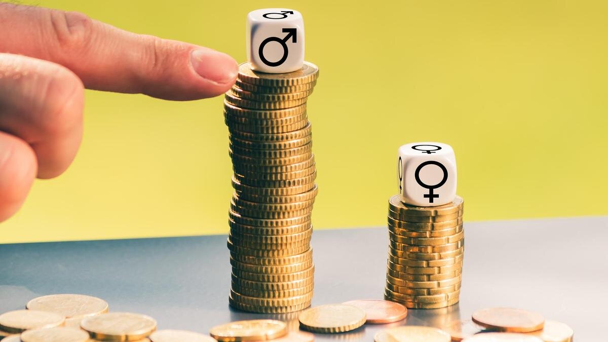    Кубики с изображением гендерных знаков стоят на стопках монет:Fokusiert/Getty Images