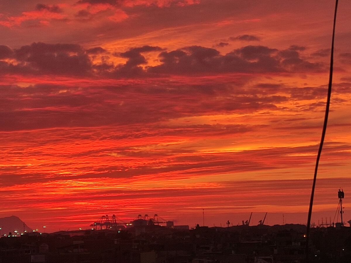 Вид из окна моего жилища в Кальяо сегодня вечером. Повышенное содержание водяного пара в атмосфере окрашивает закат в красный цвет 