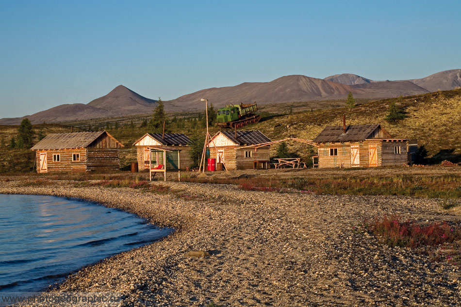 База на озере Момонтай. Справа баня. Слева большой дом. В середине два маленьких дома. Наверху старый, нерабочий вездеход.