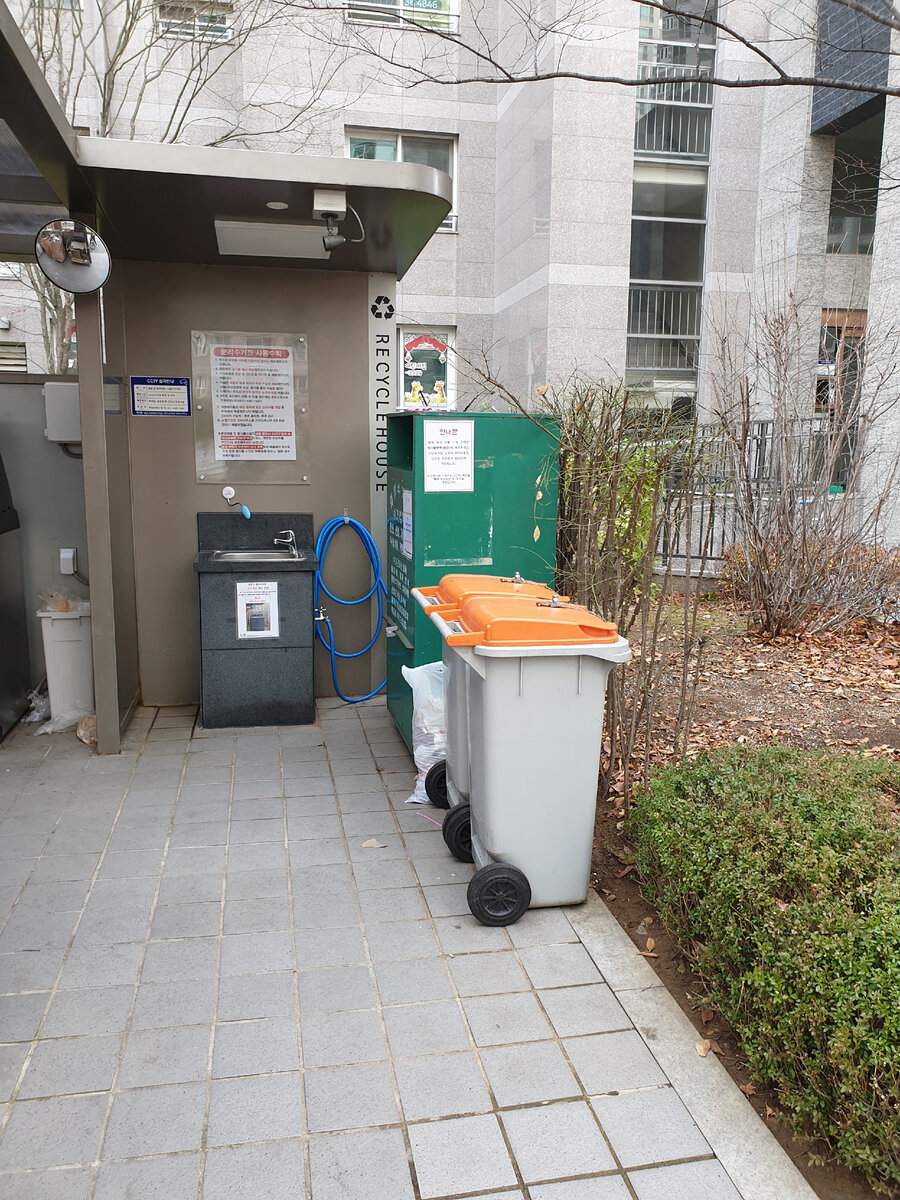 Контейнер с оранжевой крышкой деля пищевых отходов,  зелёный контейнер  для одежды, есть раковина для мытья рук
