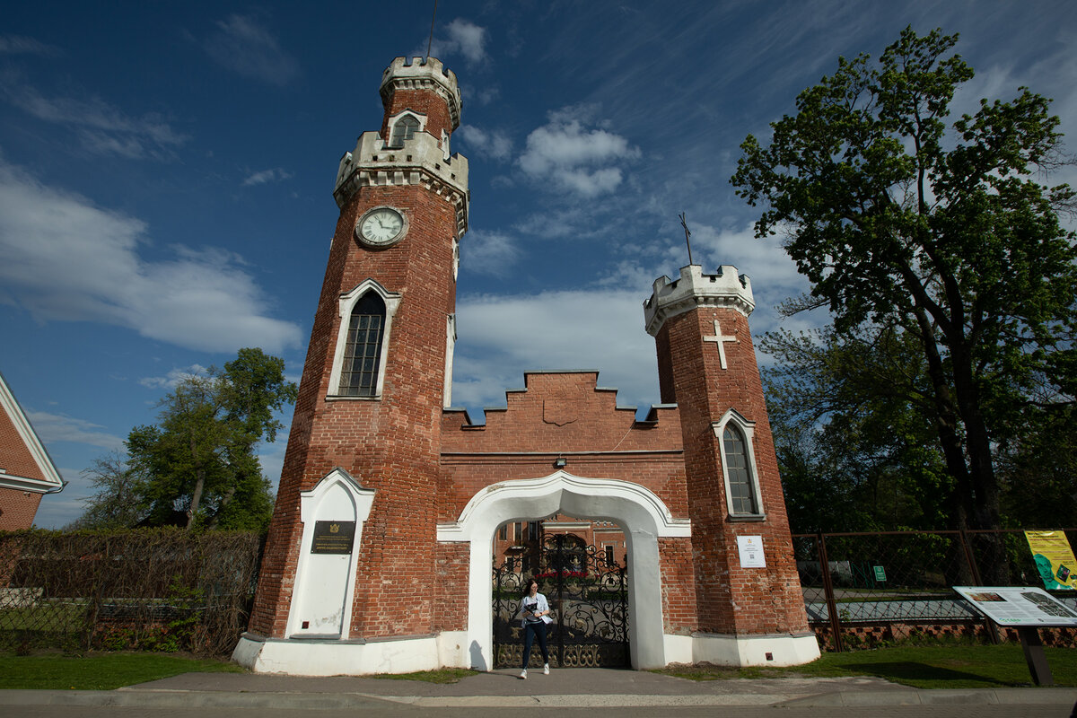 Надвратные башни с часами и крестом и чугунные ворота