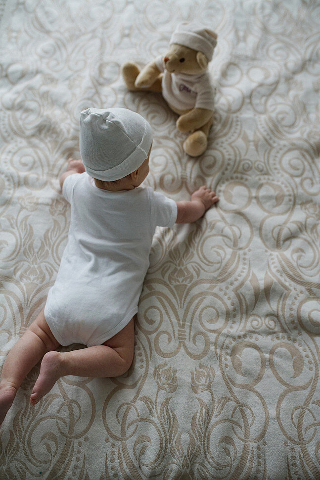 Если младенец капризничает, когда вы кладете его на живот, разложите рядом с ним игрушки.