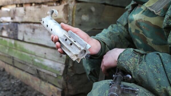    Военнослужащий ДНР демонстрирует осколок снаряда, которыми обстреливают их позиции© РИА Новости / Сергей Аверин